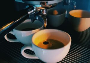 Banner con tazas de café en máquina de expresso